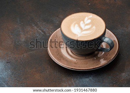 Latte art coffee on grey table. Cup of cappuccino