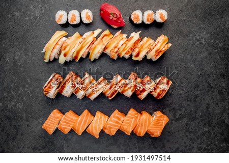 Assorted sushi set nigiri and sushi rolls on stone background