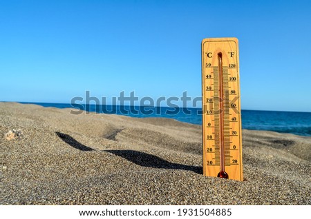 Photo Picture of a Thermometer on the Sand Beach Royalty-Free Stock Photo #1931504885