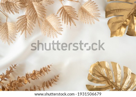 Gold tropical palm leaves Monstera on white background. Flat lay 