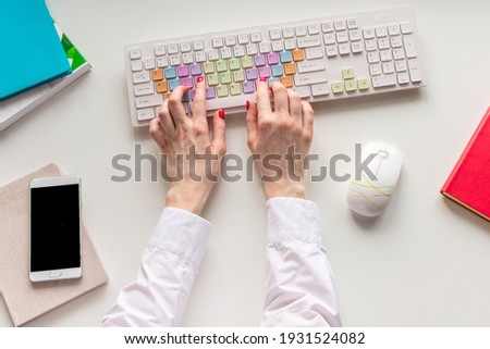 Businesswoman typing a document on a computer keyboard, woman's hands, top view, flat lay