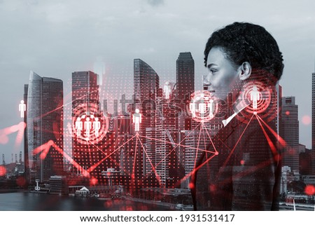Attractive black HR director at international company is thinking about recruitment of highly qualified specialists. Women in business concept. Social media hologram icons over Singapore.