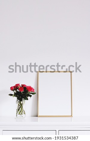 Golden horizontal frame and bouquet of rose flowers on white furniture, luxury home decor and design for mockup creations