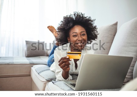 Picture showing pretty woman shopping online with credit card. Woman holding credit card and using laptop. Online shopping concept. Shot of an attractive young woman making payments online 