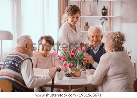 A group of senior people sitting by the table in a nursing home Royalty-Free Stock Photo #1931565671