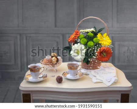 Still life with tea and basket of flowers