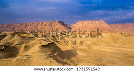 Beautiful desert landscape view towards Masada, ancient Jewish fortress in the Judean desert - location of Herod's palaces and of the Roman siege, now one of Israel's most popular tourist attractions Royalty-Free Stock Photo #1931591549