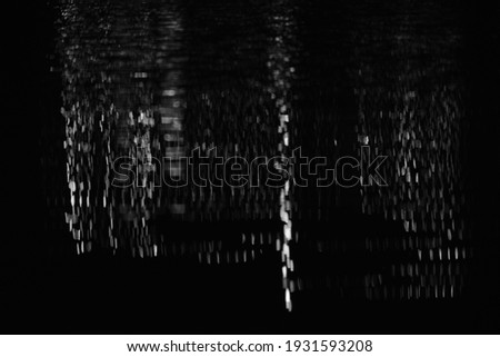 Abstract black and white city lights refection in water during night depicting the peaceful and quiet side of the city, town at night 