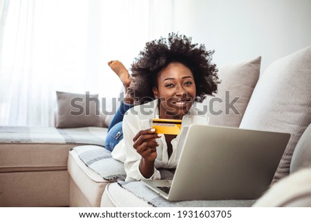 Picture showing pretty woman shopping online with credit card. Woman holding credit card and using laptop. Online shopping concept. Shot of an attractive young woman making payments online 