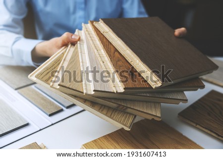 parquet floor - store salesman with flooring samples in hands Royalty-Free Stock Photo #1931607413