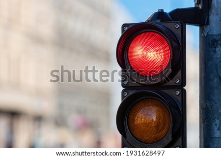 closeup of traffic semaphore with red light on defocused city street background with copy space