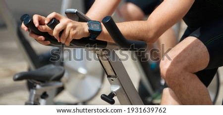 Active people working out on exercise stationary bicycle