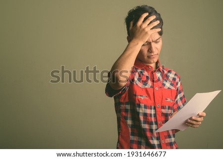 Young handsome Indian man against colored background
