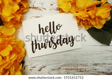 Hello Thursday Card with Blooming flower on wooden background