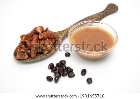 Tamarind is processed into tamarind juice in a glass bowl, tamarind seeds, tamarind leaves isolated from white background.