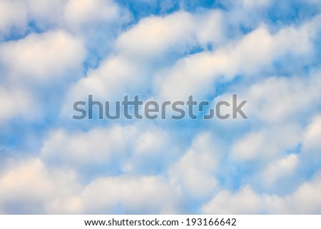 The blue sky and white fluffy clouds .