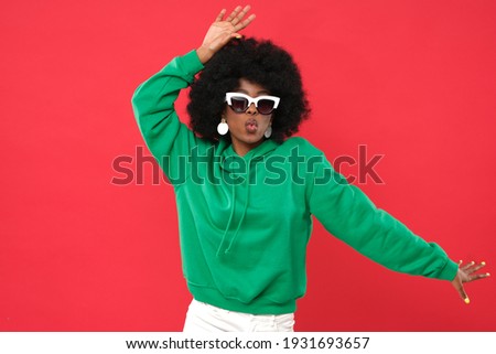 Young woman posing on red background.