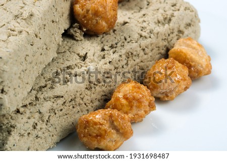 Two tiles of halva from sunflower seeds and hazelnuts in sugar glaze oriental sweets on a white plate close-up