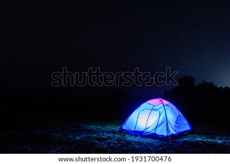 Tourist tent at night. Night sky with many stars