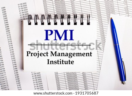 On the table are charts and reports, on which lie a blue pen and a notebook with the word PMI Project Management Institute