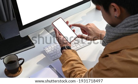 Cropped shot of asian man freelancer working online at home and using smart phone.