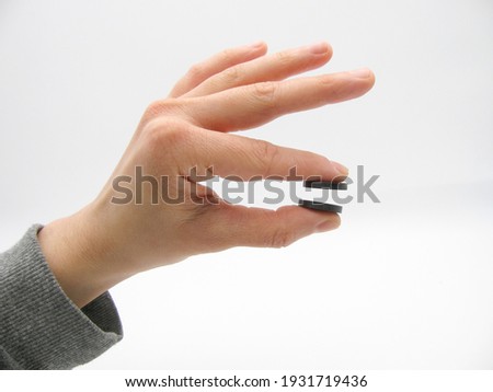 the two round little gray magnets between the two fingers of the hand do not touch each other