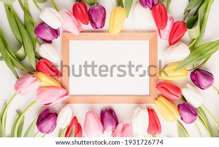 Frame mock up with beautiful colorful tulips on white background. Flat lay, top view.