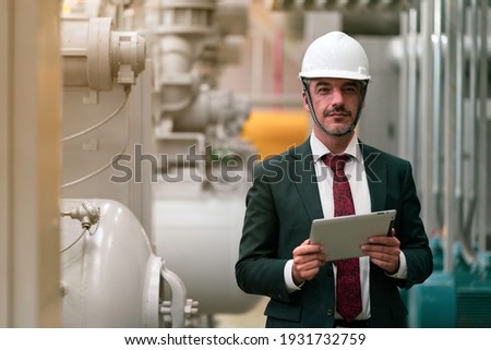Portrait shot of senior engineer or management inspecting work in the boiler room in factory Royalty-Free Stock Photo #1931732759