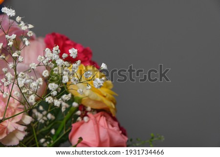 a bouquet of different types of flowers for a holiday for women with a place for text and advertising, on a gray empty background