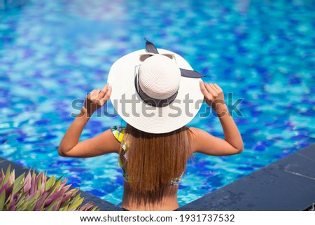 Beautiful Asian woman relaxing on the swimming pool.