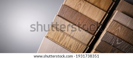 oak parquet flooring samples on gray background with copy space