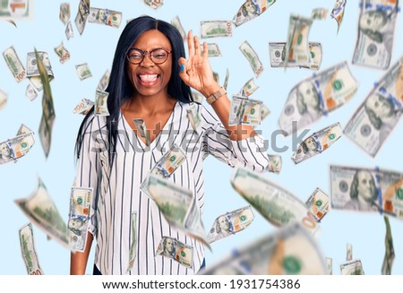Young african american woman wearing casual clothes and glasses smiling positive doing ok sign with hand and fingers. successful expression.