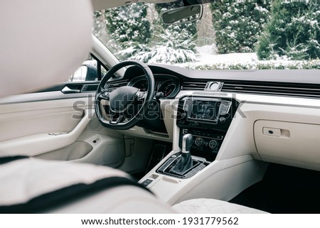 Modern car interior, white perforated leather, aluminum, black lacquer, leather steering wheel.
