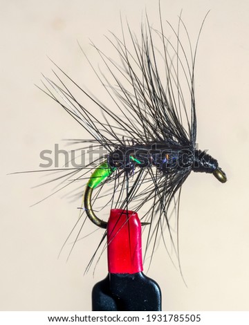 Macro shot of fly fishing lure on a black background, hand made fly for fishing