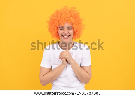 being in a good mood. happy lady having fun. going crazy. fancy party look. freaky woman in clown wig on yellow background. express positive emotions. funny girl in orange wig. april fools day.