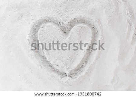 Sign or symbol of love drawing hearts on white beach sand background.