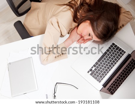 woman fallen asleep while using computer in office
