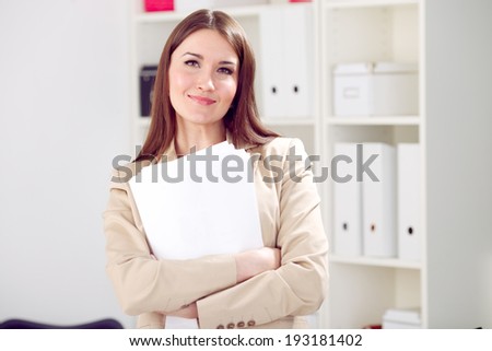 young smiling woman holding blank, paper in office