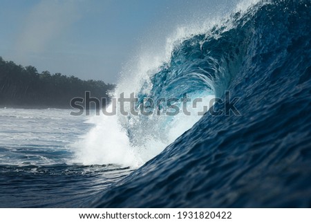Blue wave breaking on a beach in sea