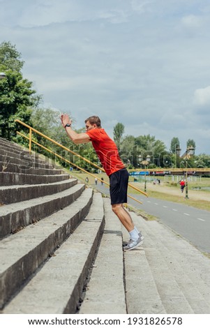 Side view picture of an active male athlete jumping up on stairs in outdoor training.