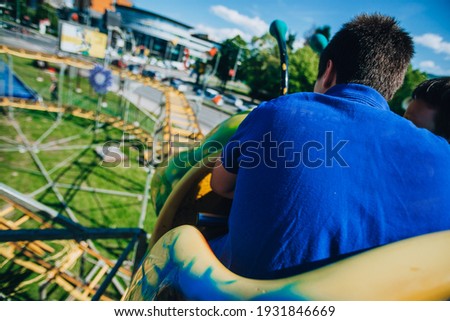Two cheerful young people sitting in a roller coaster car