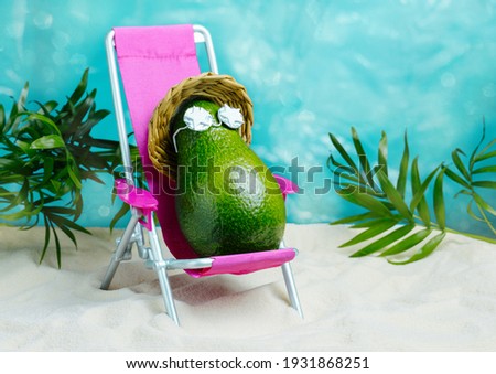 Avocado in hat and sunglasses  relaxes on  lounge chair on  beach. Summer tropical minimal humor poster.