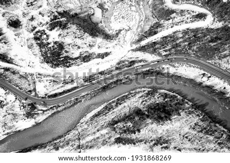 Aerial view on mountain road from drone in winter. Black and white picture