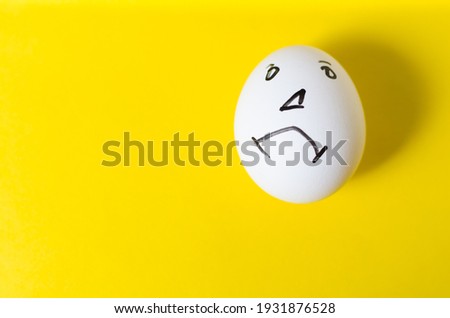 Eggs with a sad emotional face, on a yellow background.