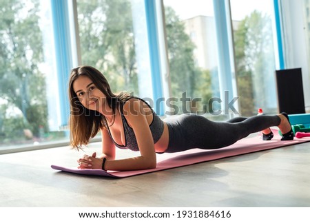 Sporty pretty girl lying on floor practising asana, doing yoga exercise at home. Recreation for healthy lifestyle 