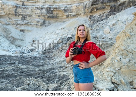 Young woman taking photos at sand rocks canyon, exploring nature, sunny weather