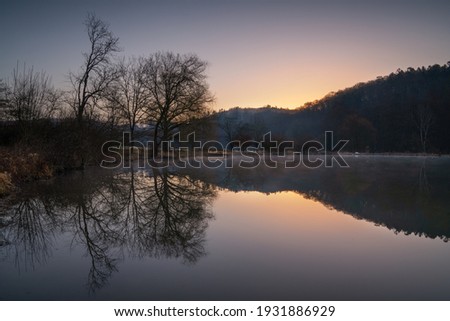 Fishpond close to Lindlar with water reflection during early morning mood, Bergisches Land, Germany Royalty-Free Stock Photo #1931886929