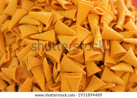 Triangle crunchy corn cheese flavor snack background. Background of crispy spicy corn snack.