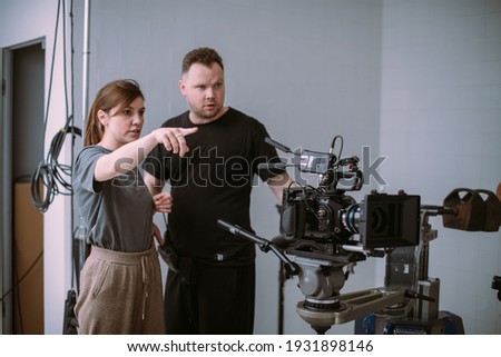 Director at work on the set. The director works with a group or with a playback while filming a movie, advertising, or a TV series. Shooting shift, equipment and group. Modern photography technique. Royalty-Free Stock Photo #1931898146