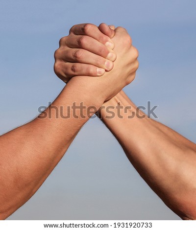 Hand rivalry vs challenge strength comparison. Man hand. Two men arm wrestling. Arms wrestling. Closep up. Friendly handshake, friends greeting, teamwork, friendship. Handshake, arms, friendship.